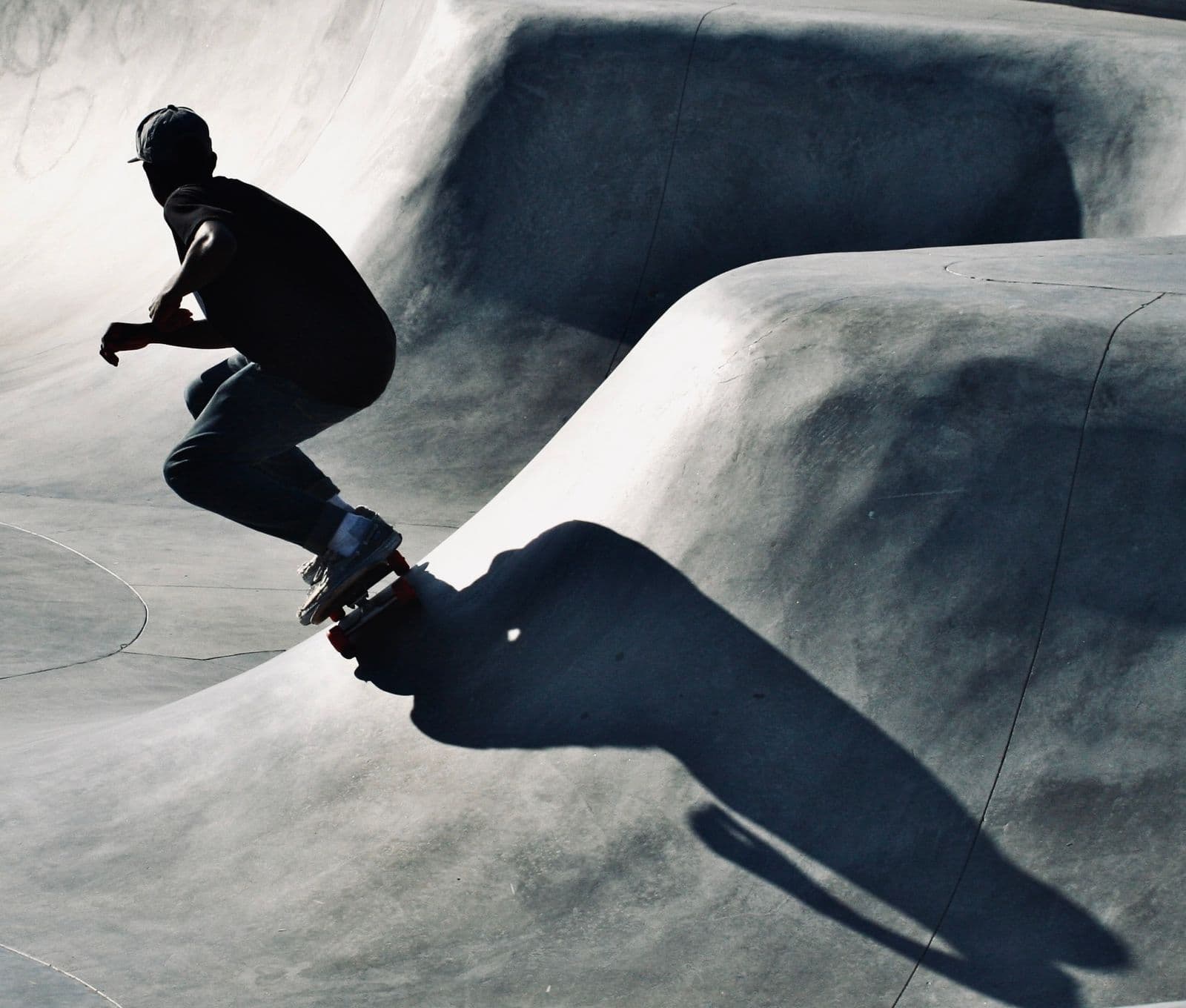 La silhouette d'un planchiste dans un bol de béton incurvé