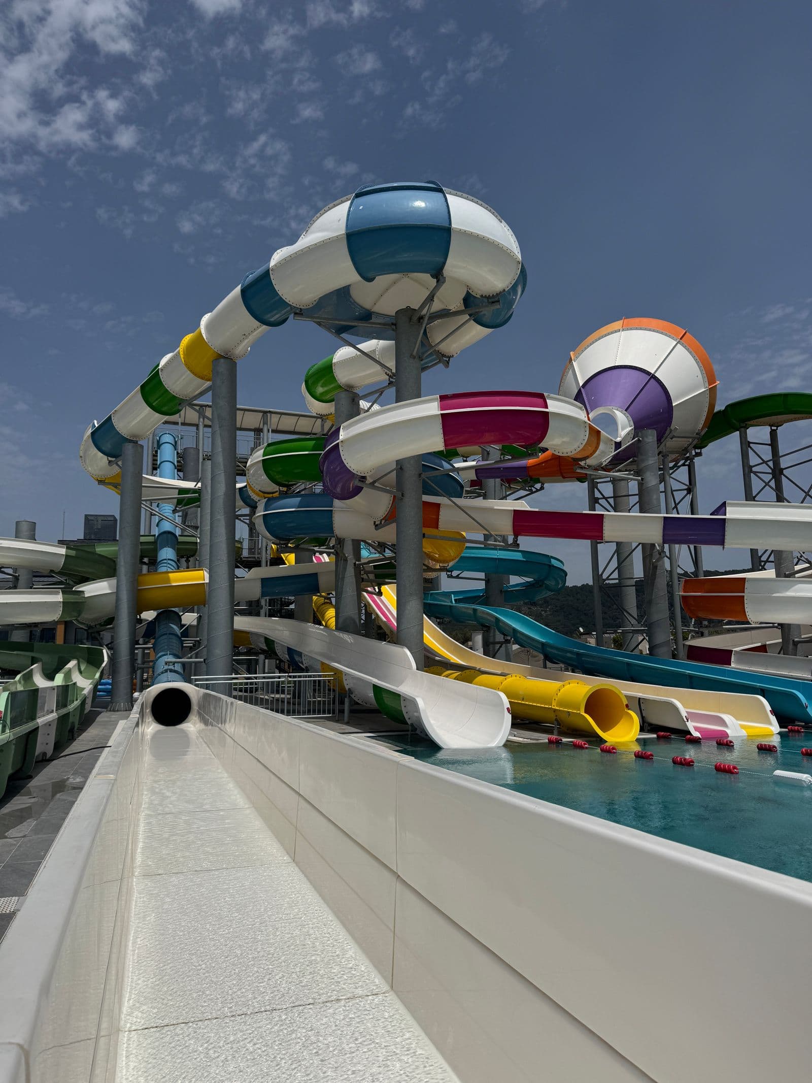 Des glissades d'eau colorées et sinueuses dans un parc aquatique extérieur par une journée ensoleillée